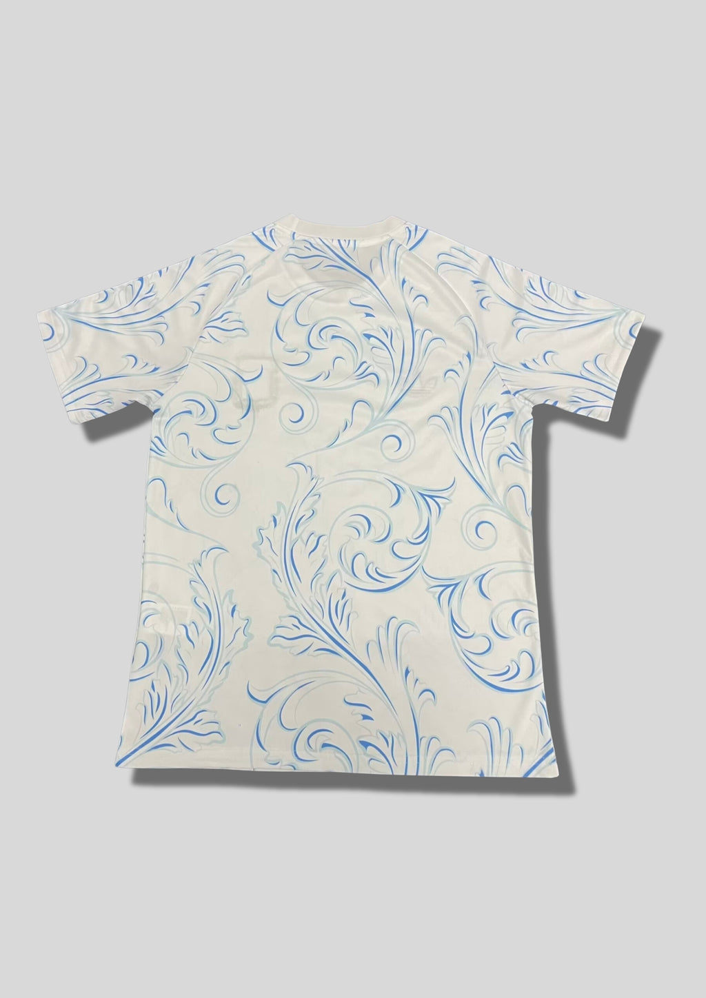Argentine 2024 (Lifestyle/Retro) Blanc, motifs floraux baroques bleus, logo Adidas Trefoil et écusson AFA classique. GoalKits