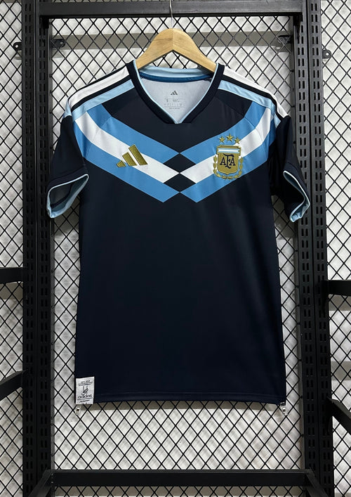 Argentine 2024 (Training/Pre-Match) Bleu marine, large chevron poitrine ciel et blanc, détails dorés. GoalKits
