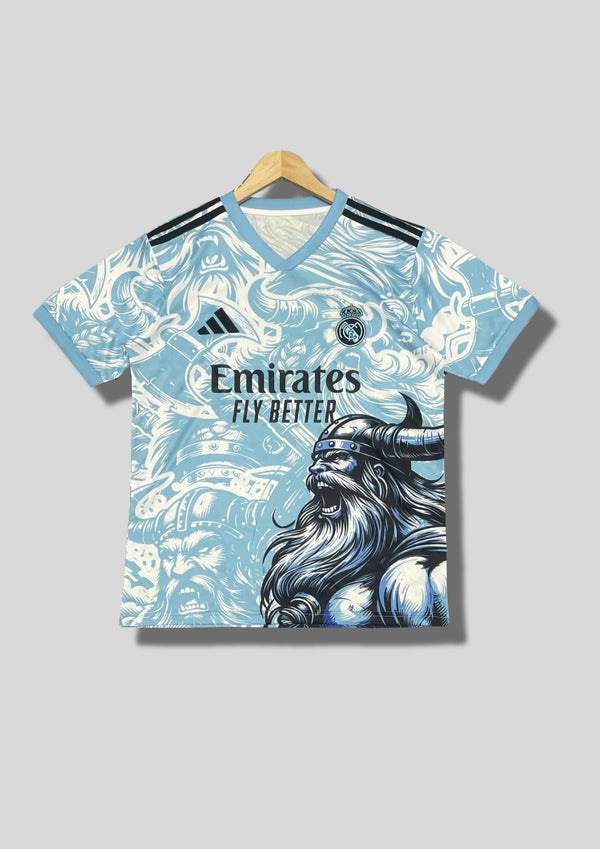 Real Madrid : Maillot d'entraînement / Édition Spéciale – Motif intégral "Viking" bleu ciel et blanc avec un guerrier barbu casqué sur le flanc. GoalKits