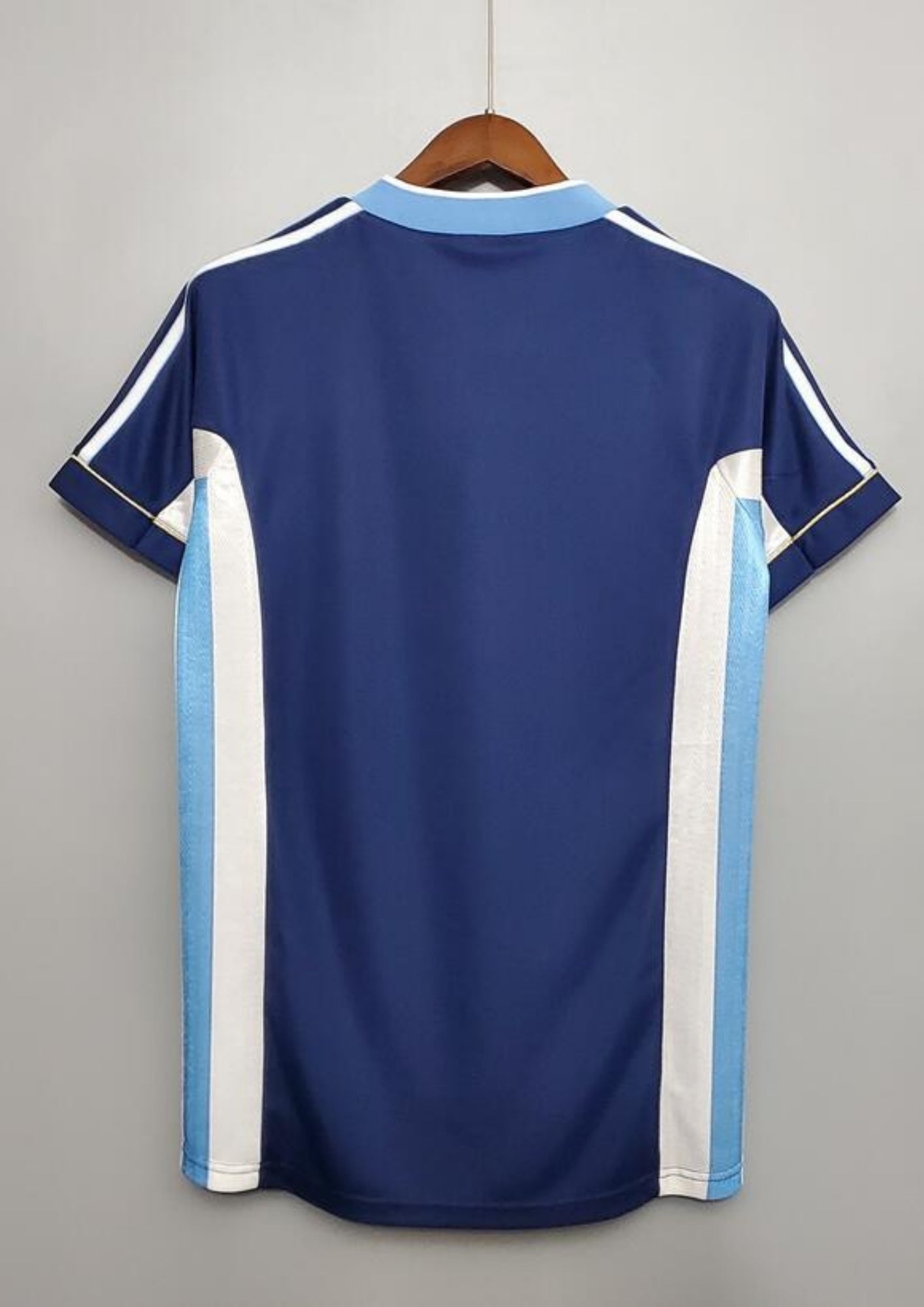 Argentine 1998 (Extérieur) Bleu marine, col en V ciel et blanc, bandes latérales tricolores, logo Adidas central blanc. GoalKits