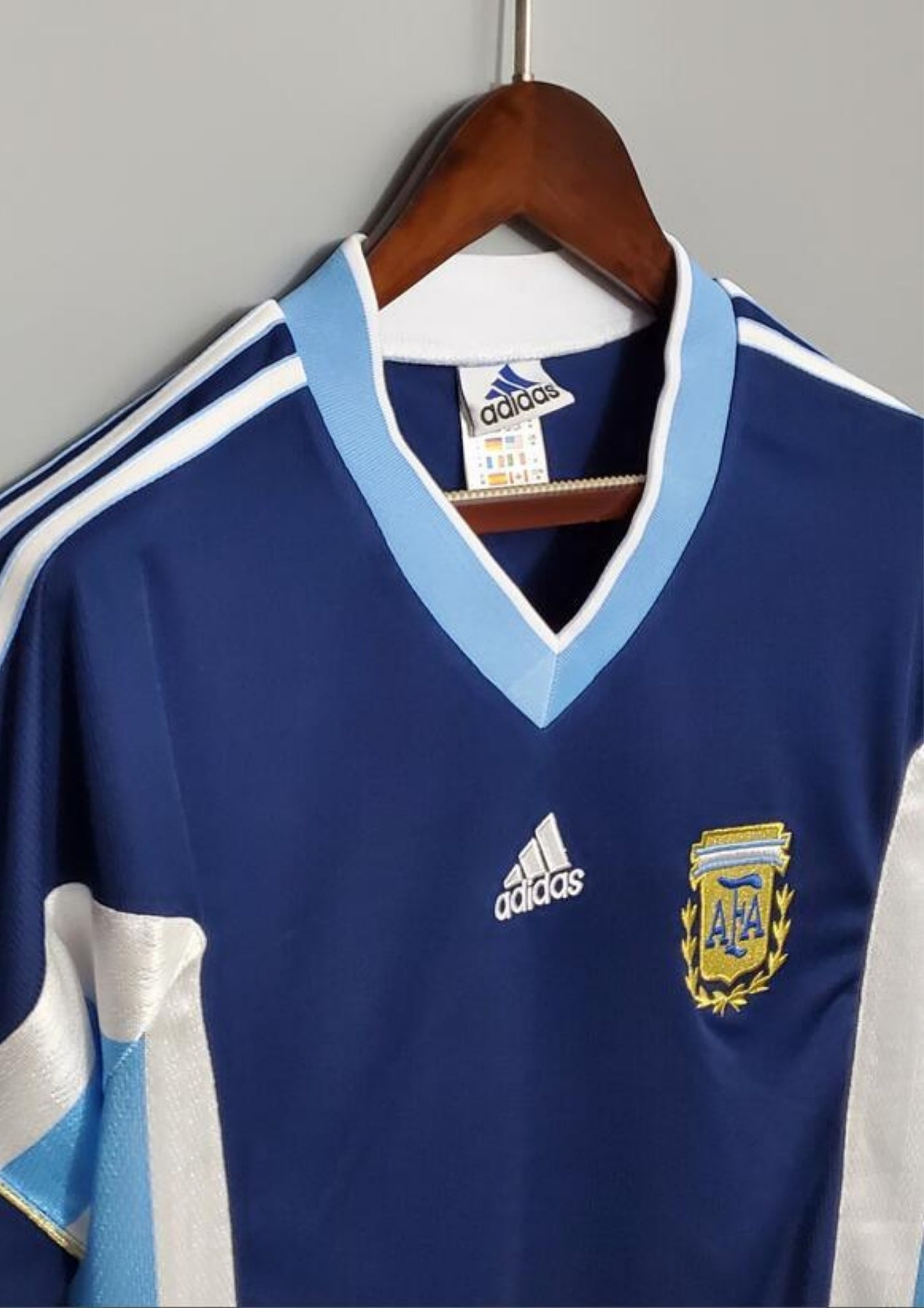 Argentine 1998 (Extérieur) Bleu marine, col en V ciel et blanc, bandes latérales tricolores, logo Adidas central blanc. GoalKits