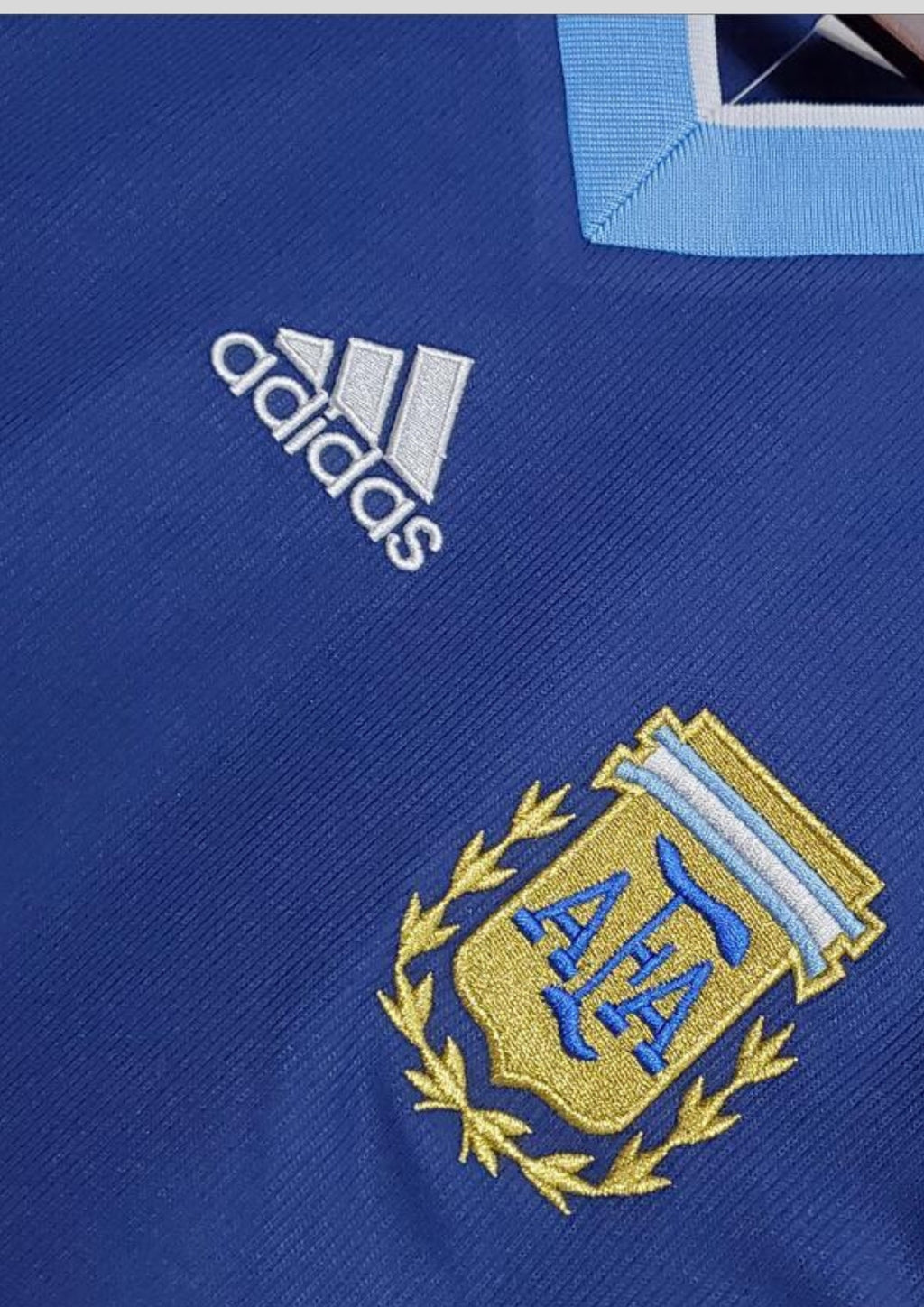 Argentine 1998 (Extérieur) Bleu marine, col en V ciel et blanc, bandes latérales tricolores, logo Adidas central blanc. GoalKits