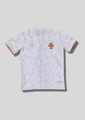 Angleterre 2024 (Concept/Lifestyle) Blanc, motifs répétitifs de têtes de lion en filigrane gris clair, écusson revisité avec croix de Saint-Georges et lions rouges, détails dorés. GoalKits