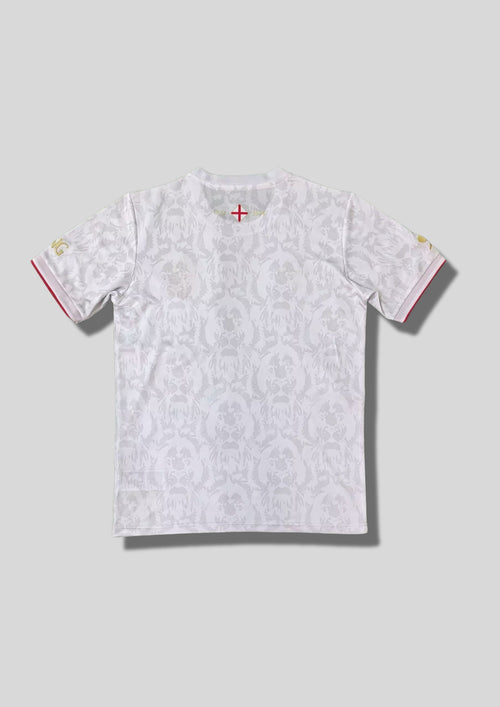 Angleterre 2024 (Concept/Lifestyle) Blanc, motifs répétitifs de têtes de lion en filigrane gris clair, écusson revisité avec croix de Saint-Georges et lions rouges, détails dorés. GoalKits