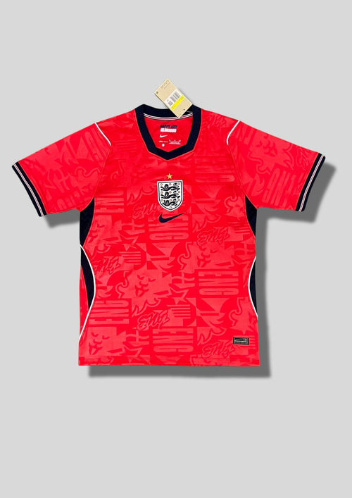 Angleterre 2024 (Pre-Match / Training) Rouge vif avec motifs graphiques "ENG" et lions en ton sur ton, col et détails latéraux bleu marine, logos centrés. GoalKits