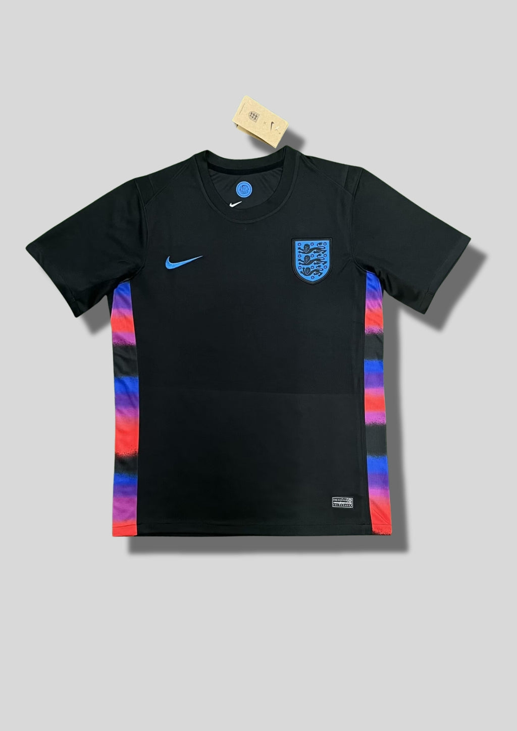 Angleterre 2024 (Training) Noir, bandes latérales multicolores (bleu, violet, rouge), virgule Nike et écusson Three Lions en bleu ciel. GoalKits
