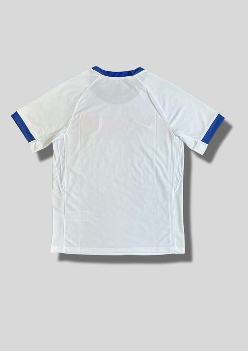Angleterre 2024 (Training / Pre-Match) Blanc avec un dégradé horizontal bleu et rouge sur le haut du torse, col et bordures de manches bleus, virgule Nike blanche. GoalKits