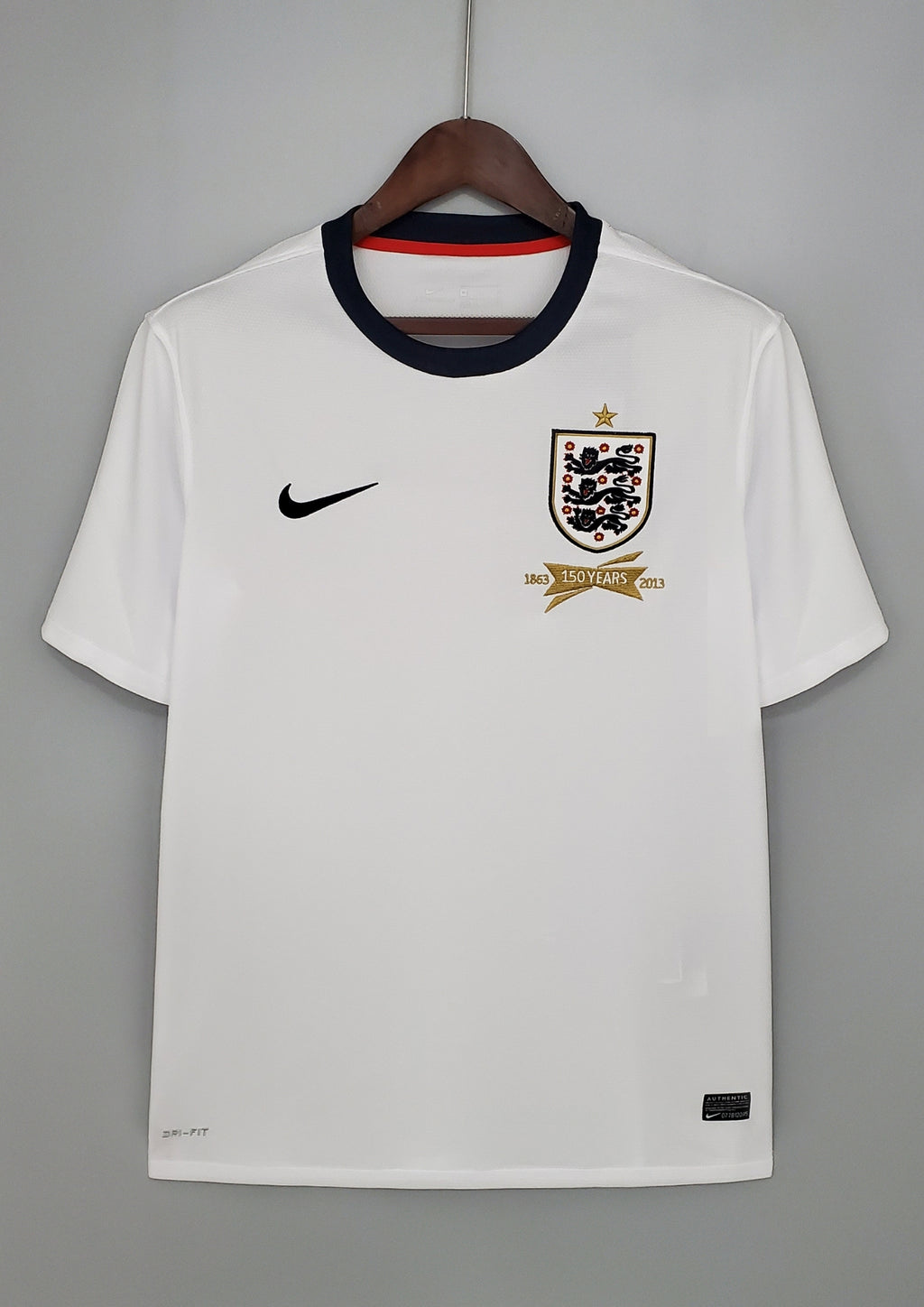 Angleterre 2024 (Concept/Cross) Blanc avec une large croix de Saint-Georges rouge centrée, bordée de fines lignes bleu marine. Le logo Nike et l'écusson des Three Lions sont placés de part et d'autre de la croix. GoalKits