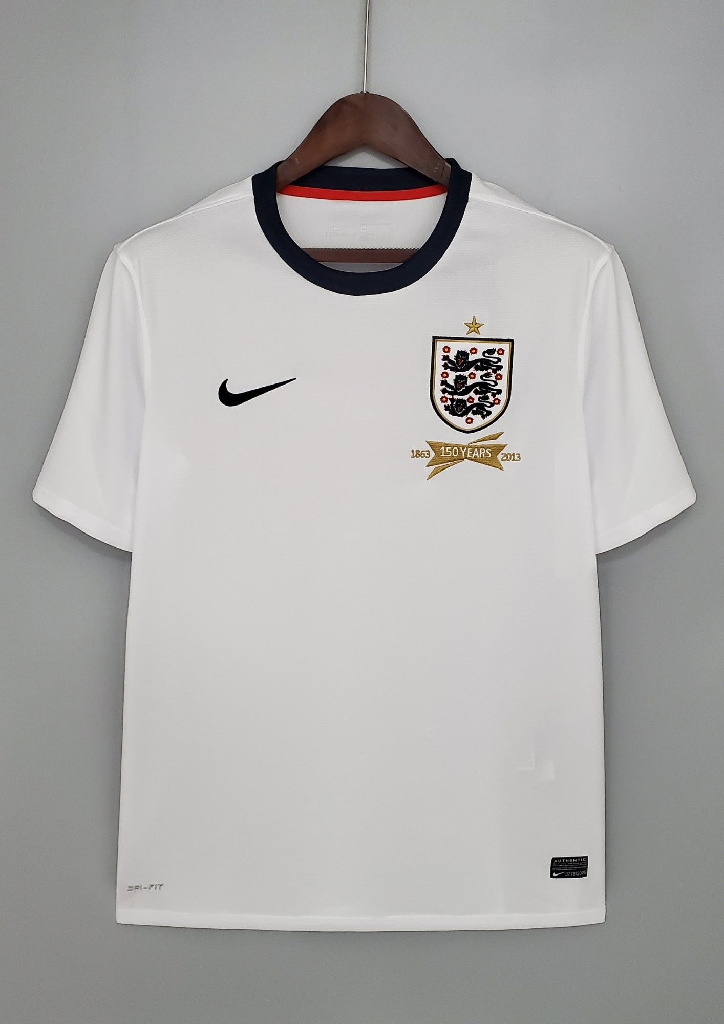 Angleterre 2024 (Concept/Cross) Blanc avec une large croix de Saint-Georges rouge centrée, bordée de fines lignes bleu marine. Le logo Nike et l'écusson des Three Lions sont placés de part et d'autre de la croix. GoalKits