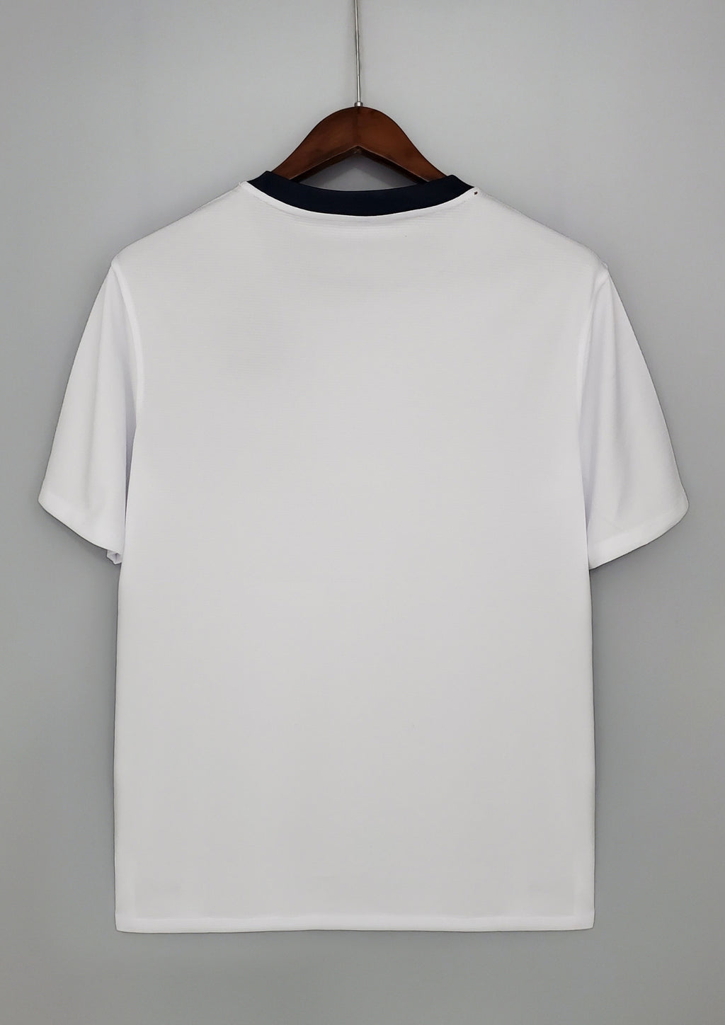 Angleterre 2024 (Concept/Cross) Blanc avec une large croix de Saint-Georges rouge centrée, bordée de fines lignes bleu marine. Le logo Nike et l'écusson des Three Lions sont placés de part et d'autre de la croix. GoalKits