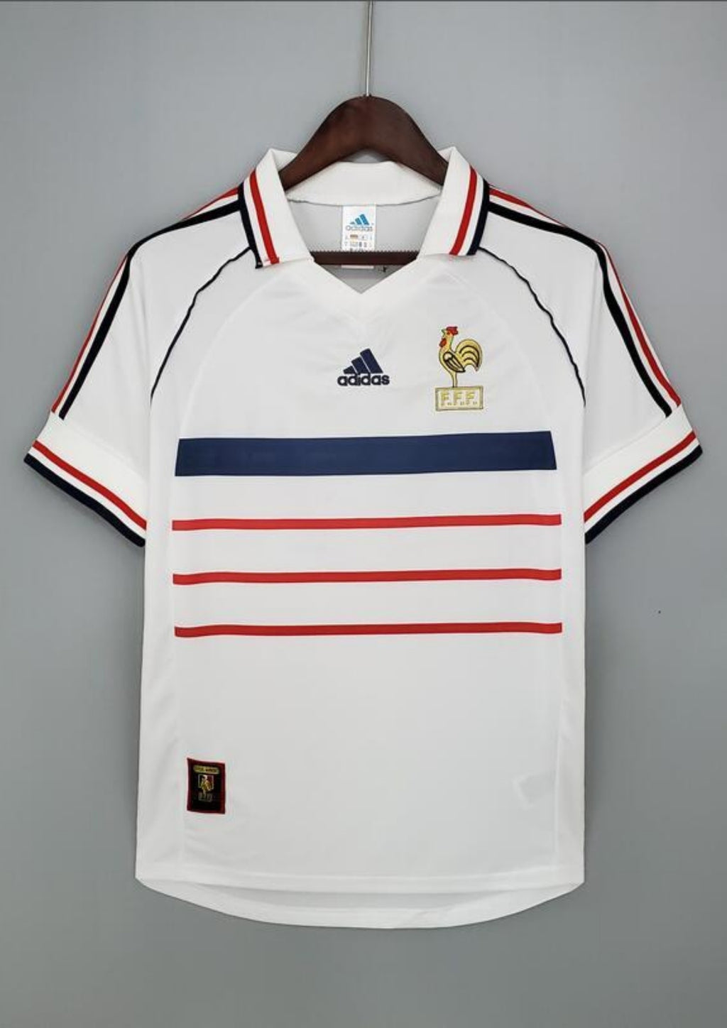 France Extérieur 1998 : Blanc, une bande bleue et trois bandes rouges horizontales, col polo. GoalKits