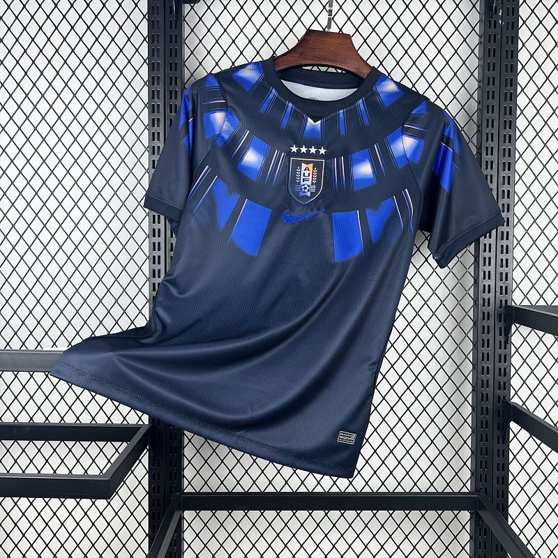 Uruguay (Édition Coupe du Monde) Bleu marine avec un motif circulaire de rayons bleus et blancs sur le torse, virgule Nike bleue et écusson de l'Uruguay centré sous quatre étoiles. GoalKits