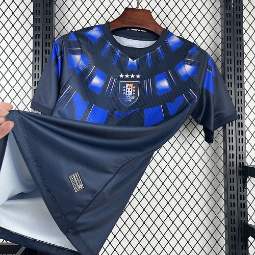 Uruguay (Édition Coupe du Monde) Bleu marine avec un motif circulaire de rayons bleus et blancs sur le torse, virgule Nike bleue et écusson de l'Uruguay centré sous quatre étoiles. GoalKits