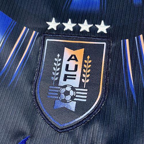 Uruguay (Édition Coupe du Monde) Bleu marine avec un motif circulaire de rayons bleus et blancs sur le torse, virgule Nike bleue et écusson de l'Uruguay centré sous quatre étoiles. GoalKits
