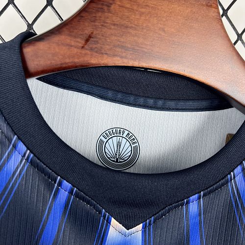 Uruguay (Édition Coupe du Monde) Bleu marine avec un motif circulaire de rayons bleus et blancs sur le torse, virgule Nike bleue et écusson de l'Uruguay centré sous quatre étoiles. GoalKits